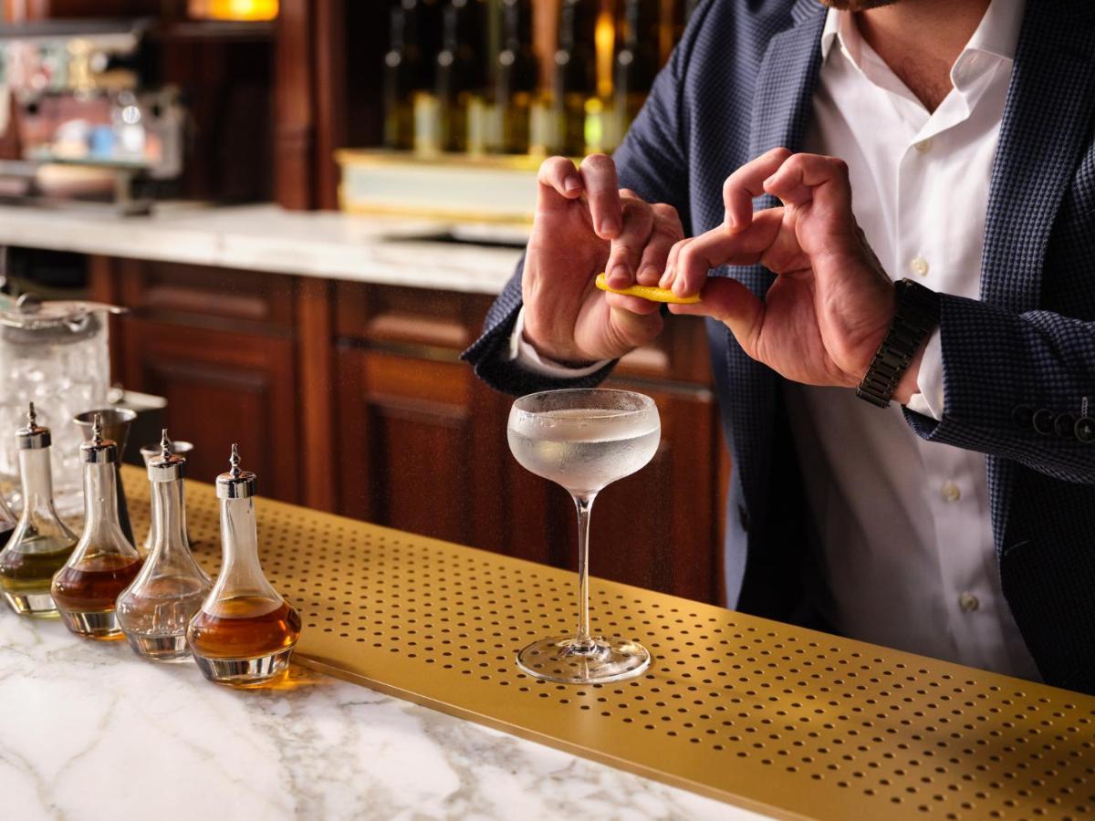 Nomad London Hotel ภายนอก รูปภาพ A bartender adding a lemon twist to a Vesper cocktail